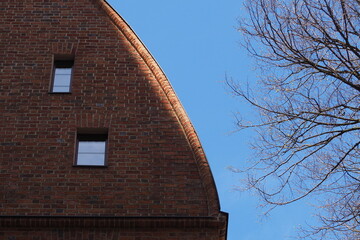 Ceglana ściana domu z oknami i promieniami słońca na krawędzi - obrazy, fototapety, plakaty