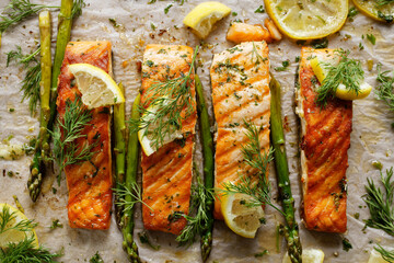Baked salmon with aromatic herbs and lemon on baking paper top view