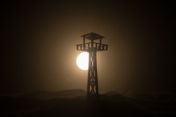 Creative artwork decoration. Silhouette of army watchtower at night. Selective focus