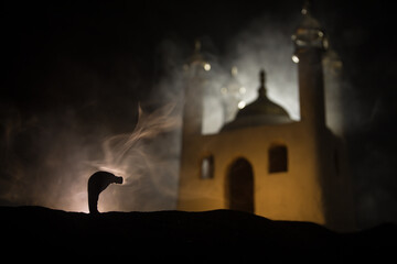 Silhouette of mosque building on toned foggy background. Ramadan Kareem background. Mosque at sunset. Praying people
