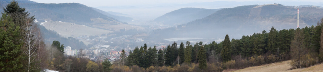 Panorama of a city in a valley between hills in winter in the morning