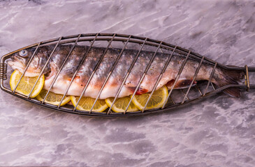 Close up view of fresh fish with lemon prepared for grilling. 