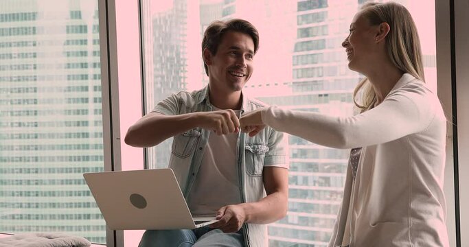 Happy male female workmates celebrate common online project accomplishment, fist bumping feel satisfied by work done. Hands gesture sign as business success, good teamwork result, cooperation concept