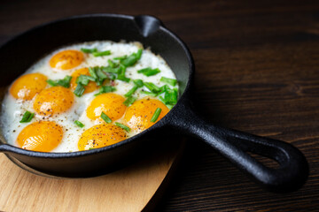frying pan with eggs on a wood table