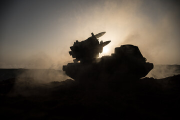 War concept. Battle scene with rocket launcher aimed at gloomy sky at sunset time. Rocket vehicle...