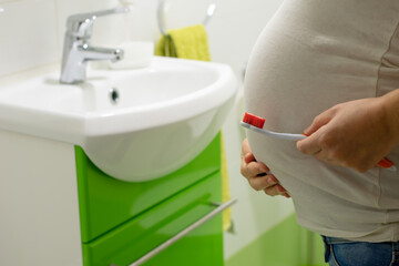 Pregnant woman holding a toothbrush