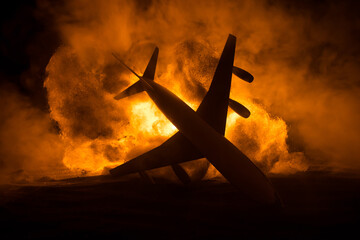 Air Crash. Burning falling plane. The plane crashed to the ground. Decorated with toy at dark fire...