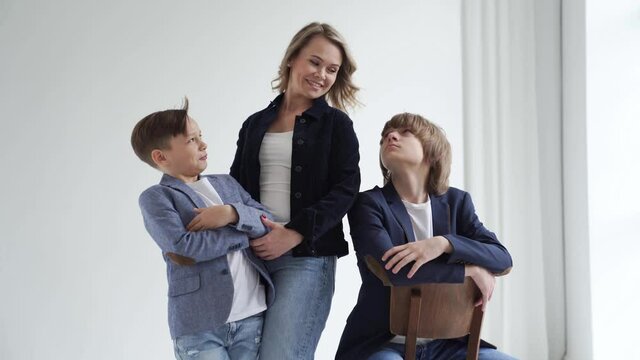 A mother with two sons in blue clothes poses for a photo shoot