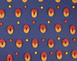 Delicious fruity gummy sweets jelly beans candies on blue trendy background