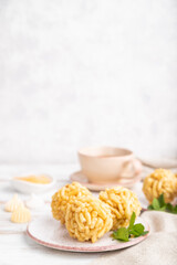 Traditional Tatar candy chak-chak made of dough and honey with cup of coffee on a white wooden background. Side view, copy space, selective focus.