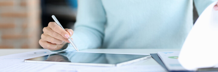 Business woman holding stylus in hands over tablet closeup