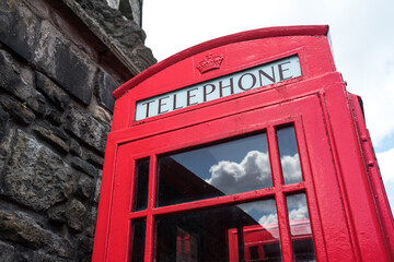 English red telephone booth and clouds reflection on windows.