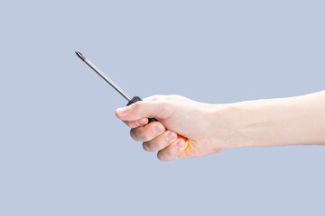handyman person holding screwdriver isolated over grey background. repair service concept