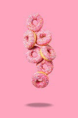 Cute pink donuts on pink background. Levitation.
