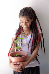 woman smiling holding a marijuana plant