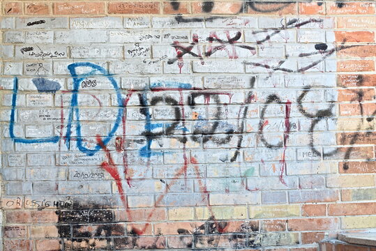 a colorful brick wall with spray can writing