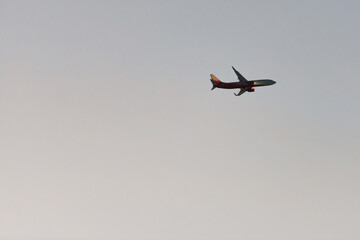 Aircraft with landing lights. The plane comes in for a landing against the darkening sky.