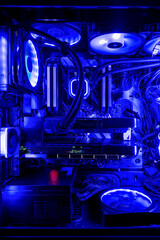 Interior of a generic DIY PC for gamers illuminated in blue. The main PC components are the motherboard, microprocessor, memory, video card, storage disks, power supply, coolers and fans.
