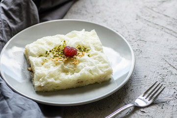Traditional Turkish Ramadan dessert gullac, milky dessert with pistachio powder and strawberry jam, ottoman cuisine