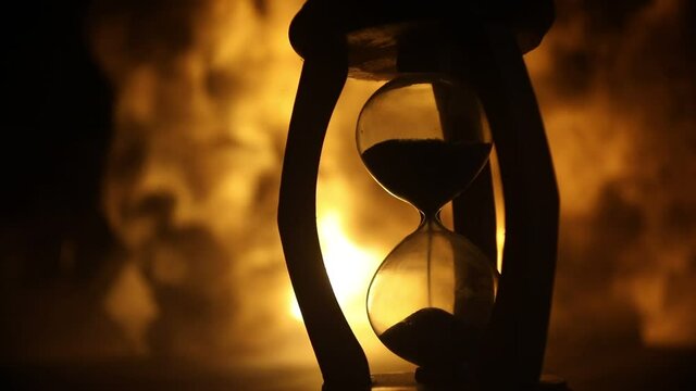 Time concept. Silhouette of Hourglass clock on dark toned background. Abstract concept with copy space. Selective focus