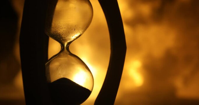 Time concept. Silhouette of Hourglass clock on dark toned background. Abstract concept with copy space. Selective focus