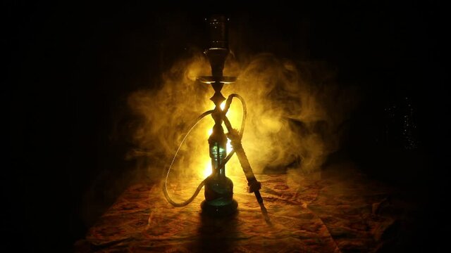 Shisha Concept. Hookah hot coals on shisha bowl with black background. Stylish oriental shisha with colorful lights. Selective focus
