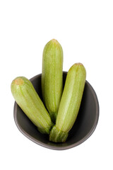 Baby courgette (zucchini) in a bowl isolated white background