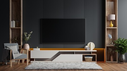Mockup a TV wall mounted in a dark room with armchair on dark wall background.