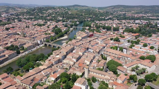 Scenic aerial view of French commune of Limoux on Aude River overlooking gothic spire of Church of Saint Martin in summer, Occitanie 
