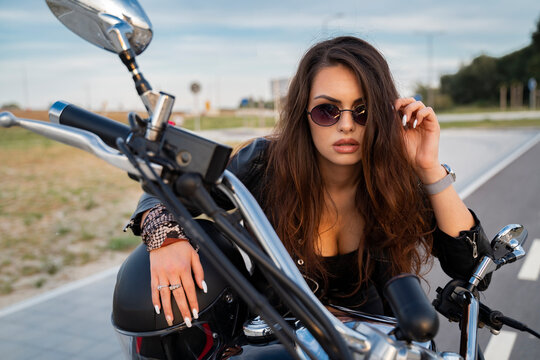 Sensual biker girl looking at camera with sunglasses on 