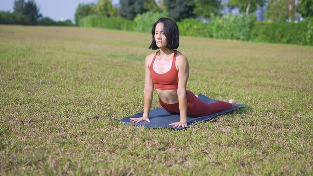 single asian chinese female yogi yoga on morning green garden meadow