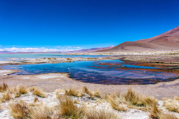 Blue lake and the mountains with snow on top at Salar de Chalviri, Bolívia 