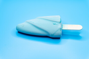 side view fresh chocolate outer with coffee inside popsicle on a blue background