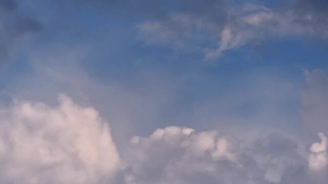 4K Time lapse, Gray and white rolling puffy clouds floating in the sky.