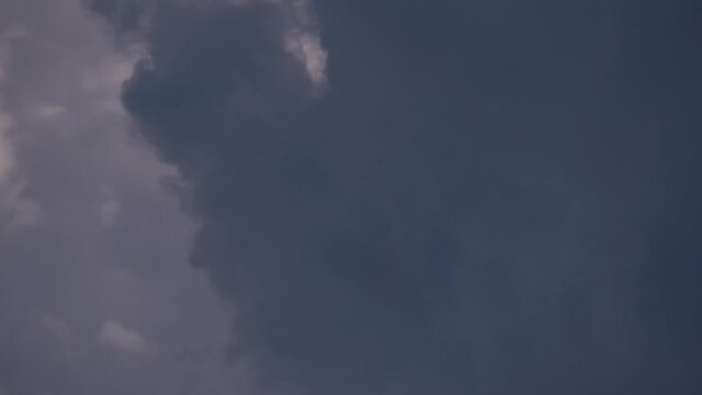 4K Time lapse, Gray and white rolling puffy clouds floating in the sky.