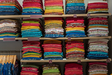 Beautiful Indian coloured cloth fabric folded on shelves for sale, India