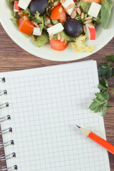 Fresh greek salad with feta cheese and notepad. Healthy nutrition