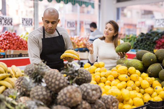 Friendly Grocery Store Employee Lays Ripe Bananas On The Counter