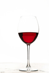 Young woman holding glass of red wine on white background. Hand with black polish.