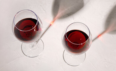 Young woman holding glass of red wine on white background. Hand with black polish.