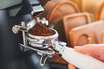 Closeup image of barista grinding coffee in coffee shop