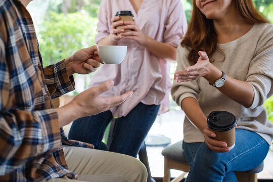 Closeup image of a group of young people enjoyed talking and drinking coffee together