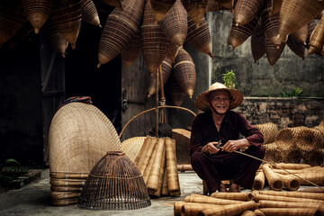 Craftsman making bamboo fish trap at old village, Hung Yen, Vietnam