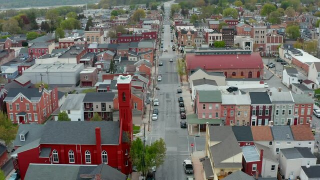 Aerial tilt up reveals beautiful Old Town in American city. Homes, church and houses line quiet streets during summer.