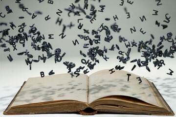 Letters of the alphabet in levitation in the air over the open book