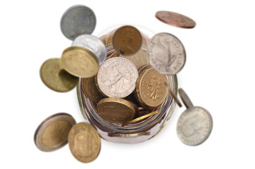 Money coins rain falling down in to the glass jar, top view selective focus