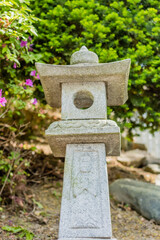 Stone carved Buddhist lantern on hillside.