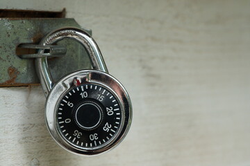 Generic combination rotary lock on wooden gate with metal latch. Words 