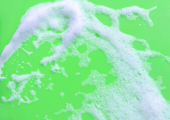 White soap foam on green background