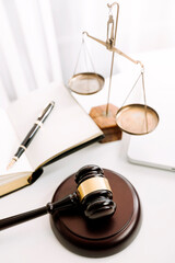 Justice and law concept.Male judge in a courtroom with the gavel, working with, computer and docking keyboard, eyeglasses, on table in morning light